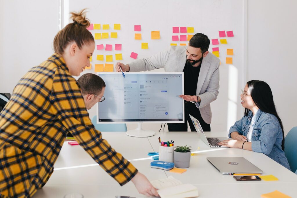 4 people in a meeting room looking at display